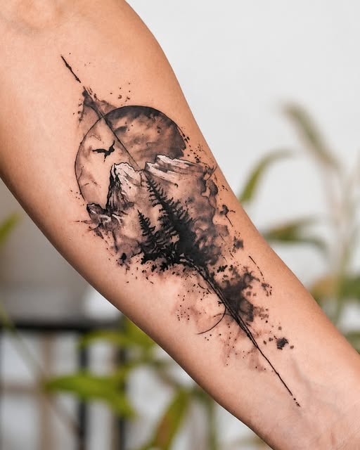 Tatuaje de paisaje con montañas, bosque y luna sobre un brazo